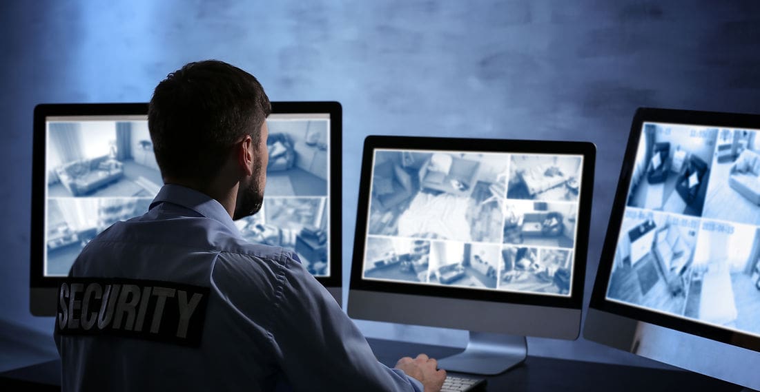 A man sitting in front of two computer monitors.